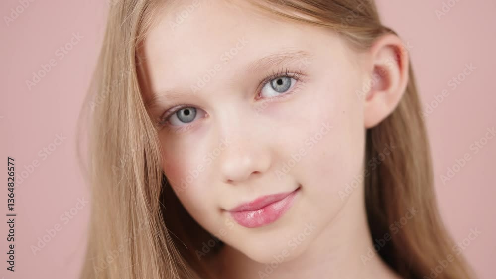 A young beautiful Generation Alpha girl with flawless fair skin, posing on a pink studio background and touching her hair. Concept of skincare for kids or teenagers, beauty portrait, and hair care. A young beautiful Generation Alpha girl with flawless fair skin, posing on a pink studio background and touching her hair. Concept of skincare for kids or teenagers, beauty portrait, and hair care.