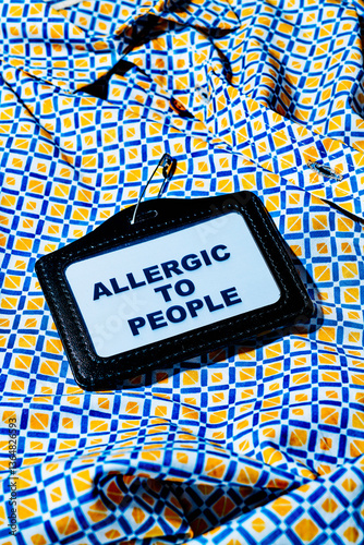 Name tag with text 'Allergic to People' on a colorful geometric shirt