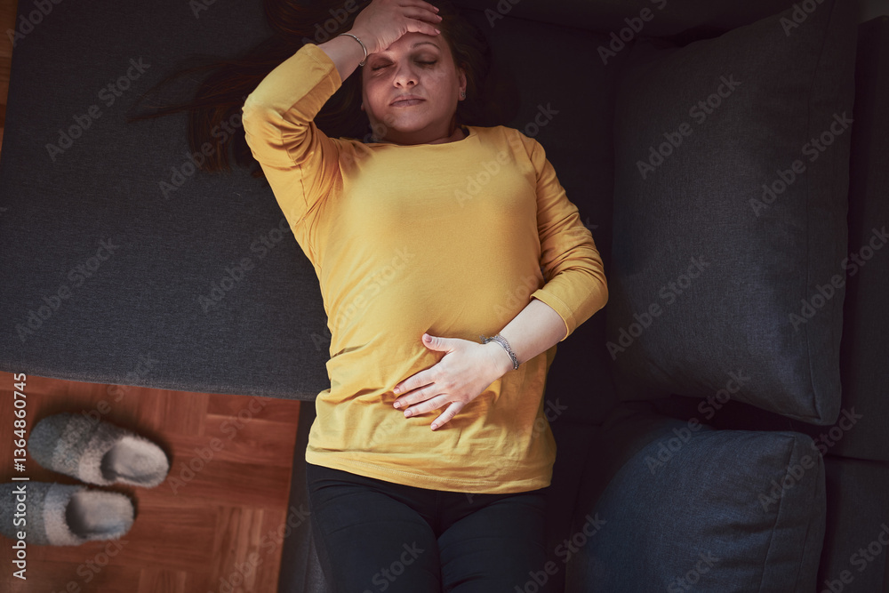 Woman with strong stomach ache, menstrual and digestive issues at home.