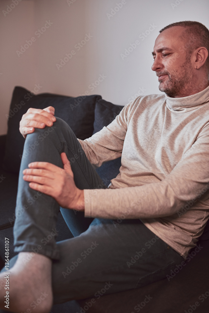 Man with painful knee and leg injury at home.