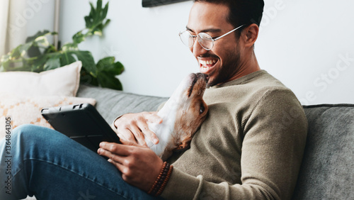 Home, dog and man with tablet, smile and relax with social media, laughing and communication. Apartment, person and guy on sofa, tech and best friend with pet, happiness and website info for animals