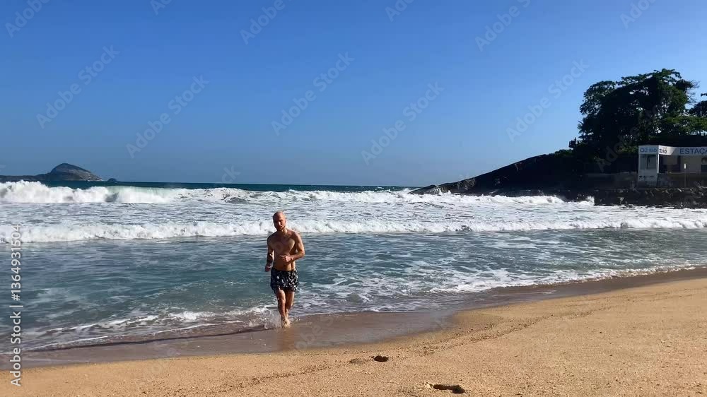 A man walks on the beach after swimming in the sea A man walks on the beach after swimming in the sea
