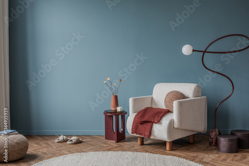 Cozy reading nook with cream armchair, terracotta accents, and sculptural floor lamp on blue wall.