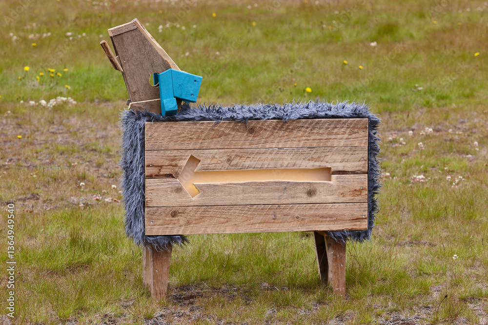 Picturesque wooden sheep sculpture covered with blue fur. Iceland countryside