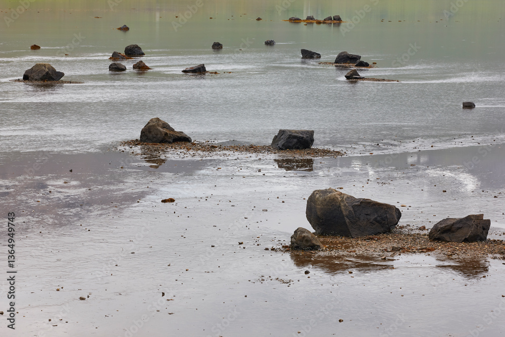 Basaltic rocks in a lake landscape. Volcanic scenery. Iceland environment