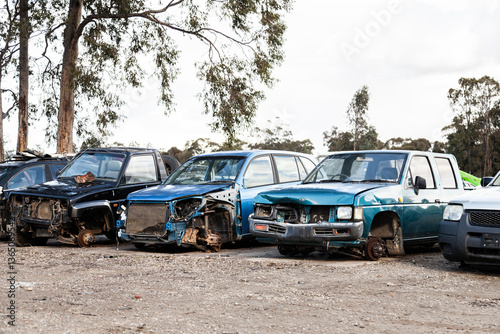 Wrecked and smashed cars parked in car wreckers junkyard photo