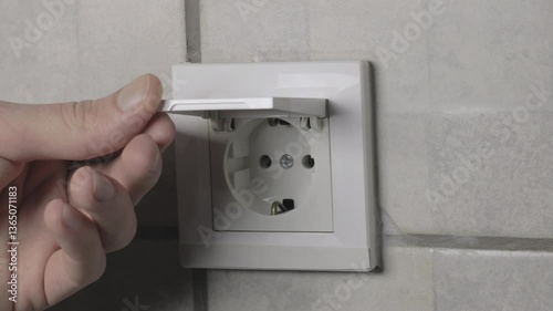 Man is closing safety waterproof electricity switch socket with cover in bathroom. Close up, 4k footage.