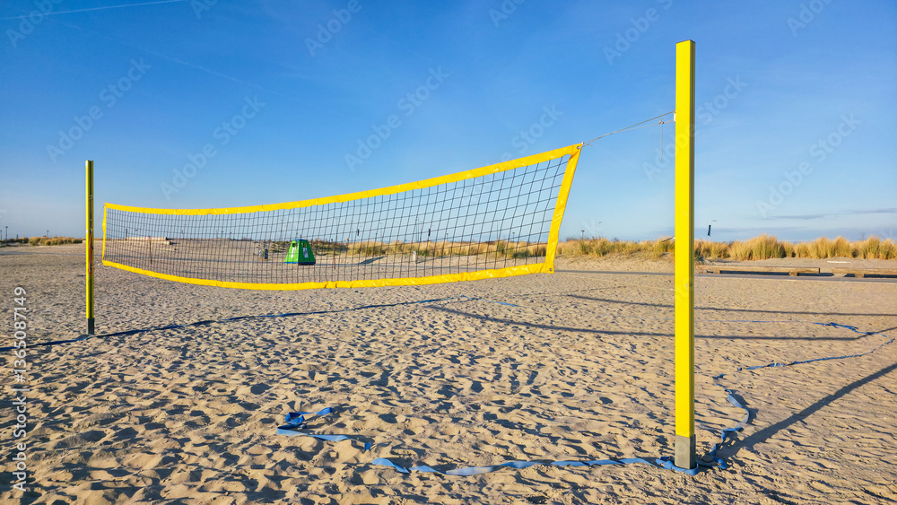 Beach volleyball net on sandy beach and blue sky