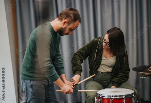 A focused music lesson where a mentor teaches drumming techniques to an aspiring musician.