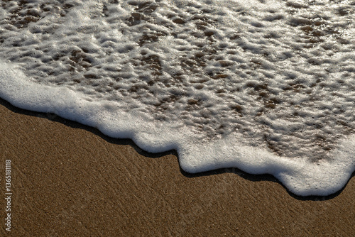 Fototapeta Naklejka Na Ścianę i Meble -  Sea foam illuminated by the sun on the sand beach close up background.  Mediterranean,  Turkey