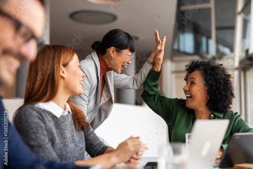 Behang Team Celebrates Success with Enthusiastic High Five in Office
