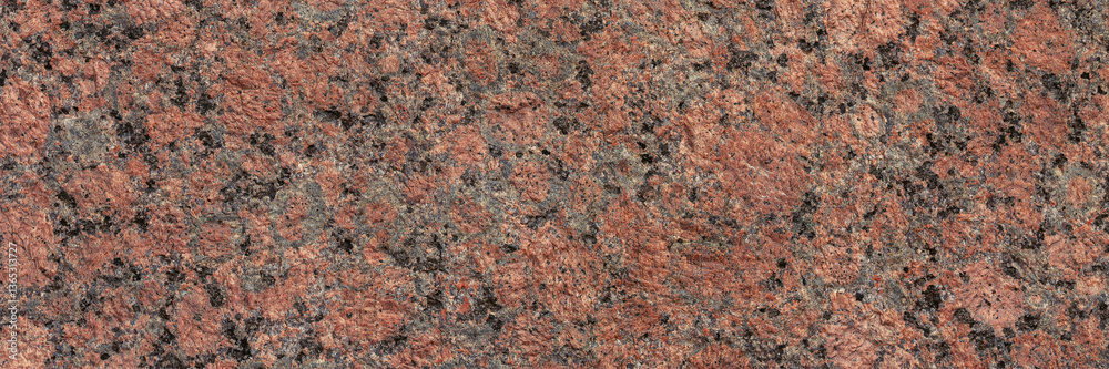 Granite texture. Natural pink granite with a grainy pattern. Stone background. Solid rough surface of rock. Durable construction and decoration material. Close-up.