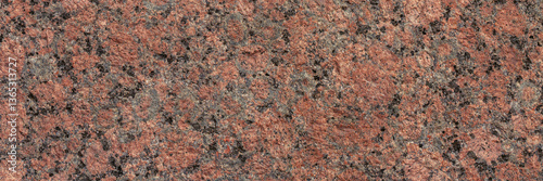 Granite texture. Natural pink granite with a grainy pattern. Stone background. Solid rough surface of rock. Durable construction and decoration material. Close-up.