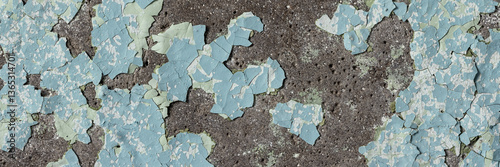 Obraz na płótnie Peeling paint on the wall. Panorama of a concrete wall with old cracked flaking paint. Weathered rough painted surface with patterns of cracks and peeling. Grunge texture for wide panoramic background w salonie
