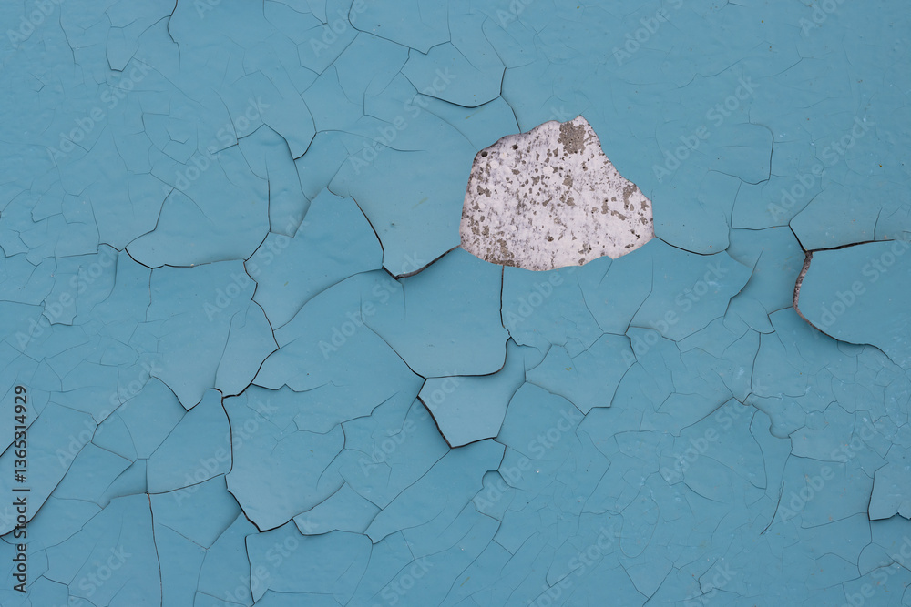 Blue peeling paint on the wall. Old concrete wall with cracked flaking paint. Weathered rough painted surface with patterns of cracks and peeling. High resolution texture for background and design.