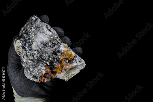 Arsenopyrite (FeAsS), iron arsenic sulfide mineral. Metallic, steel grey, silver color. Found in association with gold, potential source for toxic arsenic. Held in hand with protective glove. Black