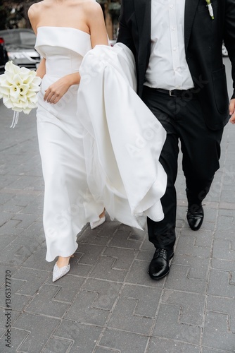 Bride and groom in motion. Man holding dress helping. Support of beloved