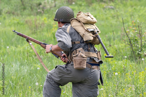 Vászonkép US Army infantryman during World War II runs to attack with a rifle