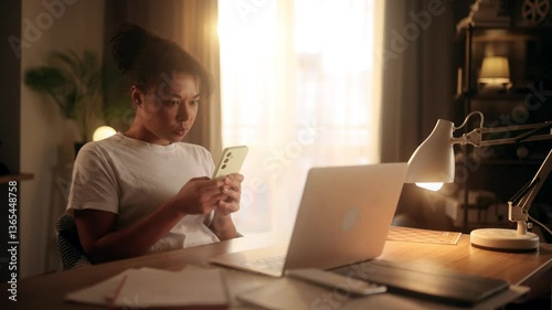 A frustrated woman in a white t-shirt sits at a desk, angrily typing a message on her phone. Her facial expression shows tension and irritation. Daytime scene