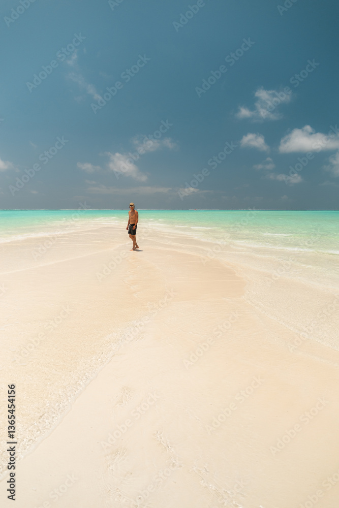 Young man walking on nakupenda sandbar beach in zanzibar, tanzania, enjoying turquoise water and white sand Young man walking on nakupenda sandbar beach in zanzibar, tanzania, enjoying turquoise water and white sand