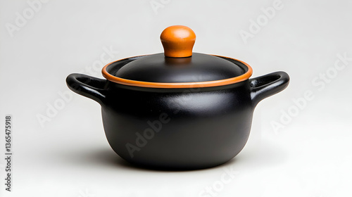 Black ceramic pot with orange lid and handles
