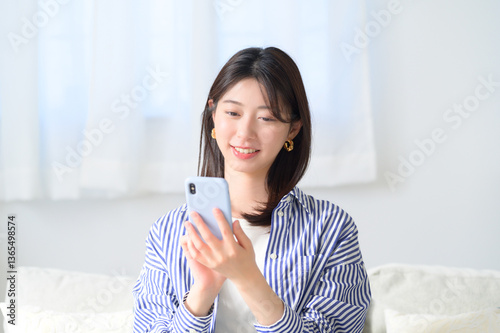 スマホを持って微笑む日本人女性