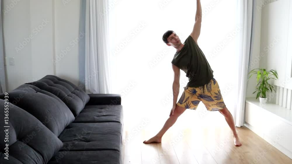 homem faz exercicios de alongamento e ioga em casa 