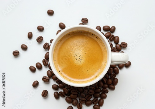 Overhead view of coffee cup surrounded by coffee beans on a white surface creating a simple design