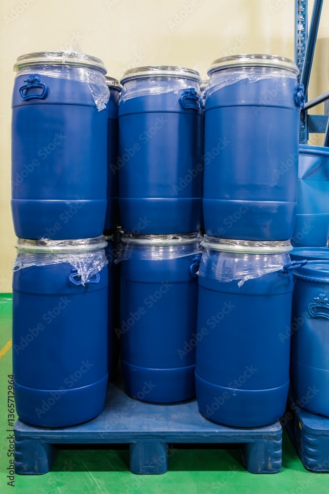 Closeup view of barrels stacked on top of each other. Blue plastic tanks on pallets in a chemical warehouse Closeup view of barrels stacked on top of each other. Blue plastic tanks on pallets in a chemical warehouse