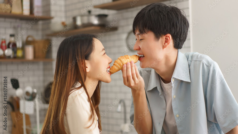 Loving girlfriend feeding her boyfriend bread in kitchen during fun cooking time