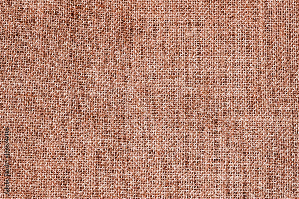 Fototapeta premium Burlap texture closeup with rough natural fiber surface in warm brown tones. Rustic burlap texture perfect for eco design, organic themes, craft backgrounds. Brown sacking texture. Grunge jute texture