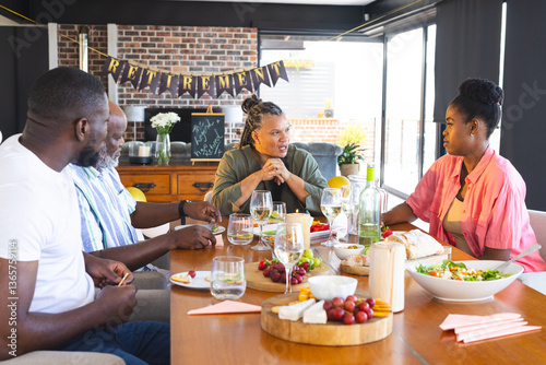 Adult family celebrating retirement with food and drinks, sharing stories at dining table