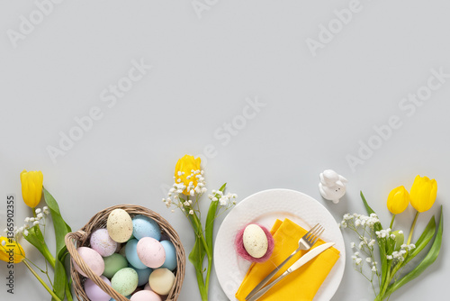 Obraz na płótnie Easter frame with pastel yellow eggs, tulip flowers, gypsophila and yellow chick on gray background. View from above. Flat lay. Happy Easter greeting card. w salonie