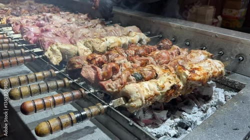 Kebabs on skewers, pilaf. Christmas food court, fair, preparing treats in the open air, winter. Evening fair. Hot, delicious food. Selective focus. Cooking shish kebab