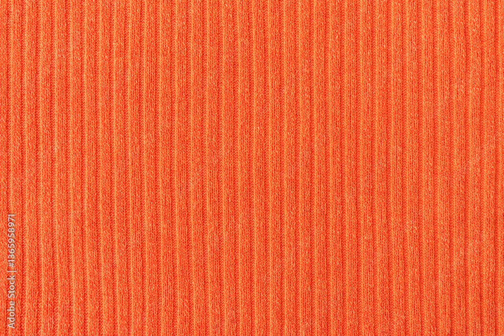 Fototapeta premium Close-up of orange fabric with a pattern of vertical lines. Soft, warm and elegant textile background.