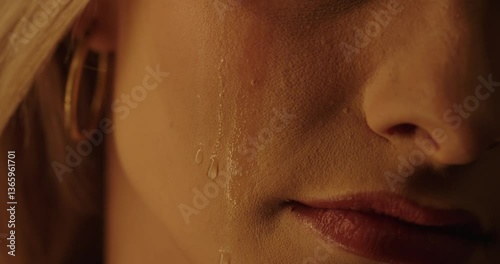 A tear flows down the cheek of a beautiful woman in slow motion, without eyes