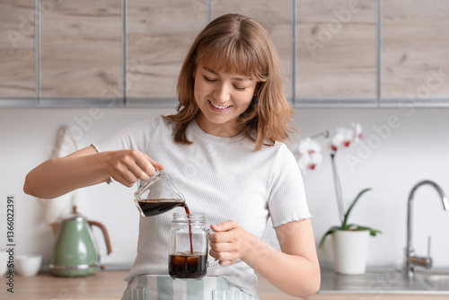 Young woman pouring coffee ...