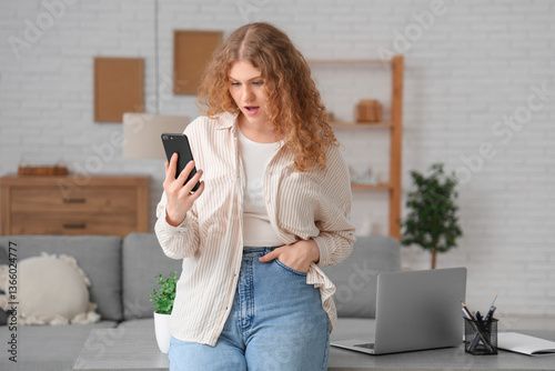 Shocked young woman using m...