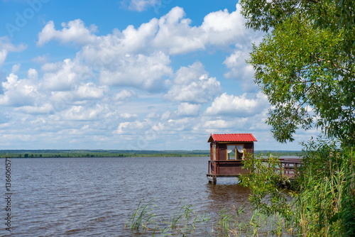 Fototapeta Naklejka Na Ścianę i Meble -  Gazebo on the lake shore on a summer day