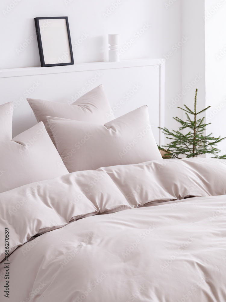 Obraz premium Scandinavian style bedroom with a double bed, fluffy down comforter and four pillows. Close-up side view vertical photo.