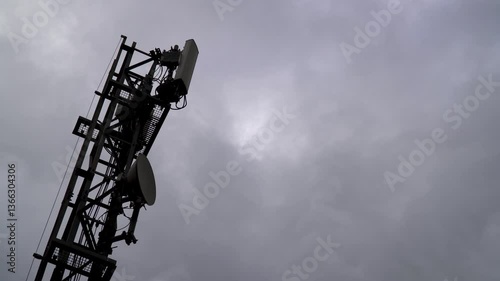 Telecommunications antennas over a cloudy sky.