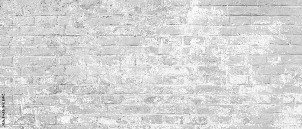 Fototapeta premium A brick wall as white background. The wall is covered in white paint and has a rough texture
