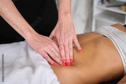 Close up of physiotherapist massaging stomach of female patient during physical therapy session