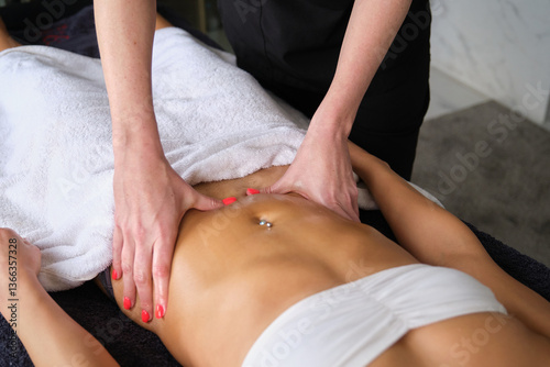Obraz na płótnie Masseuse applying pressure on stomach of young woman during slimming massage treatment w salonie