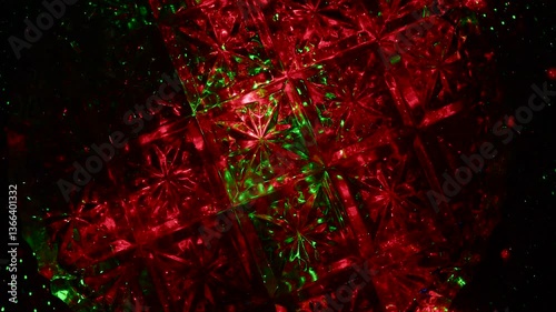 The crystal surface in the shape of flowers rotates and passes through itself rays of green and red light.
