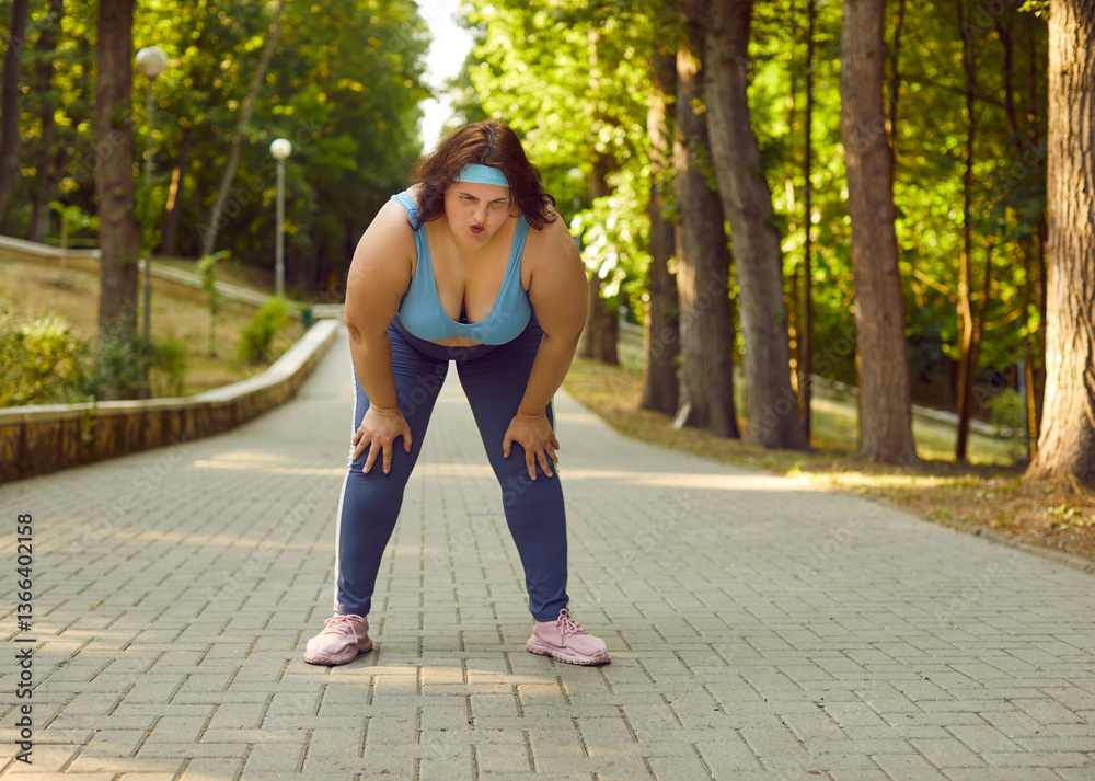 Portrait of a young fat overweight woman wearing sportswear tired after fit sport exercises or jogging in the summer park outdoors. Workout in nature, fitness and body positive concept. Portrait of a young fat overweight woman wearing sportswear tired after fit sport exercises or jogging in the summer park outdoors. Workout in nature, fitness and body positive concept.