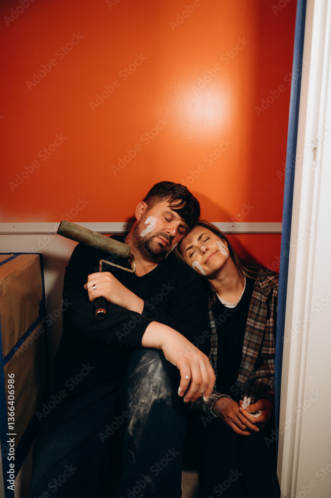 Tired people are sitting on the floor, taking a break after a long renovation effort. Tired people are sitting on the floor, taking a break after a long renovation effort.