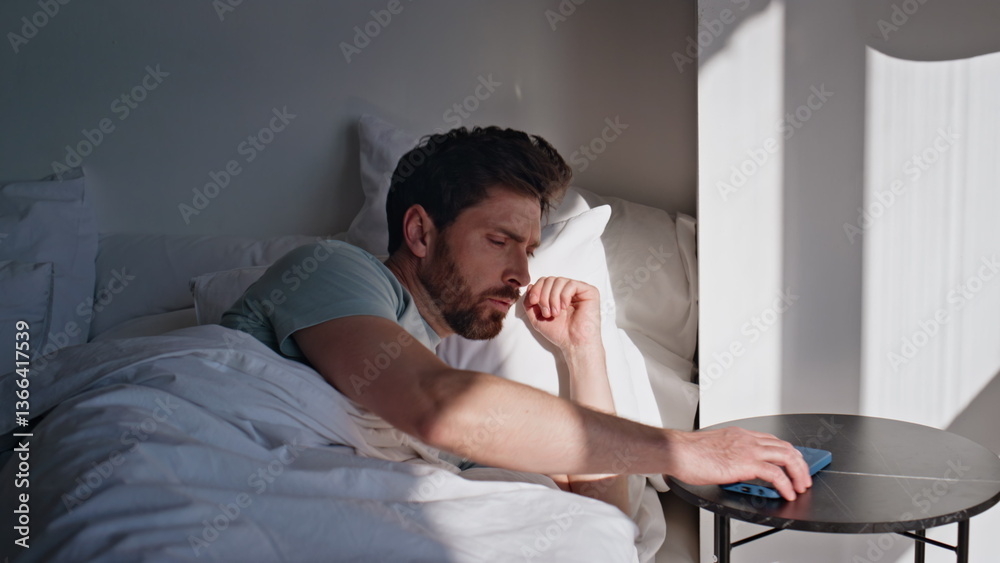 Fototapeta premium Awaking brunette looking smartphone screen bed closeup. Smiling man read message