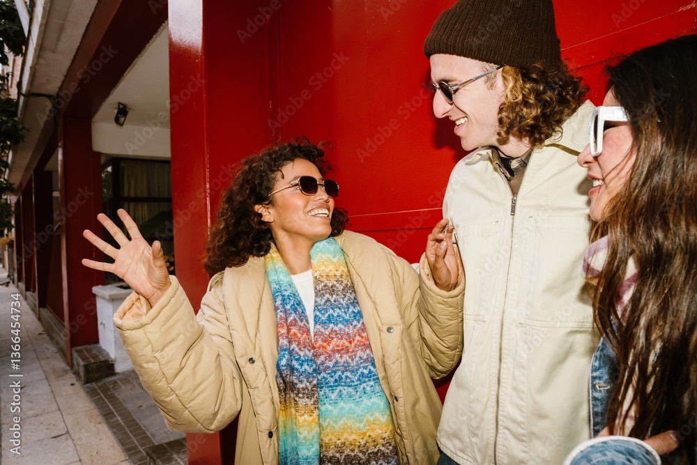 Obraz premium A woman stands and looks at a friend who is standing next to a friend, they are laughing, on the street