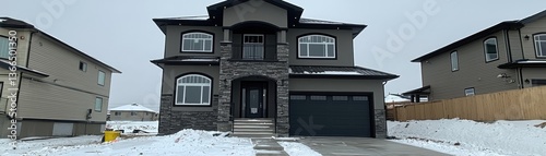 Newly built house in a snowy suburb, gray skies background, for property listing